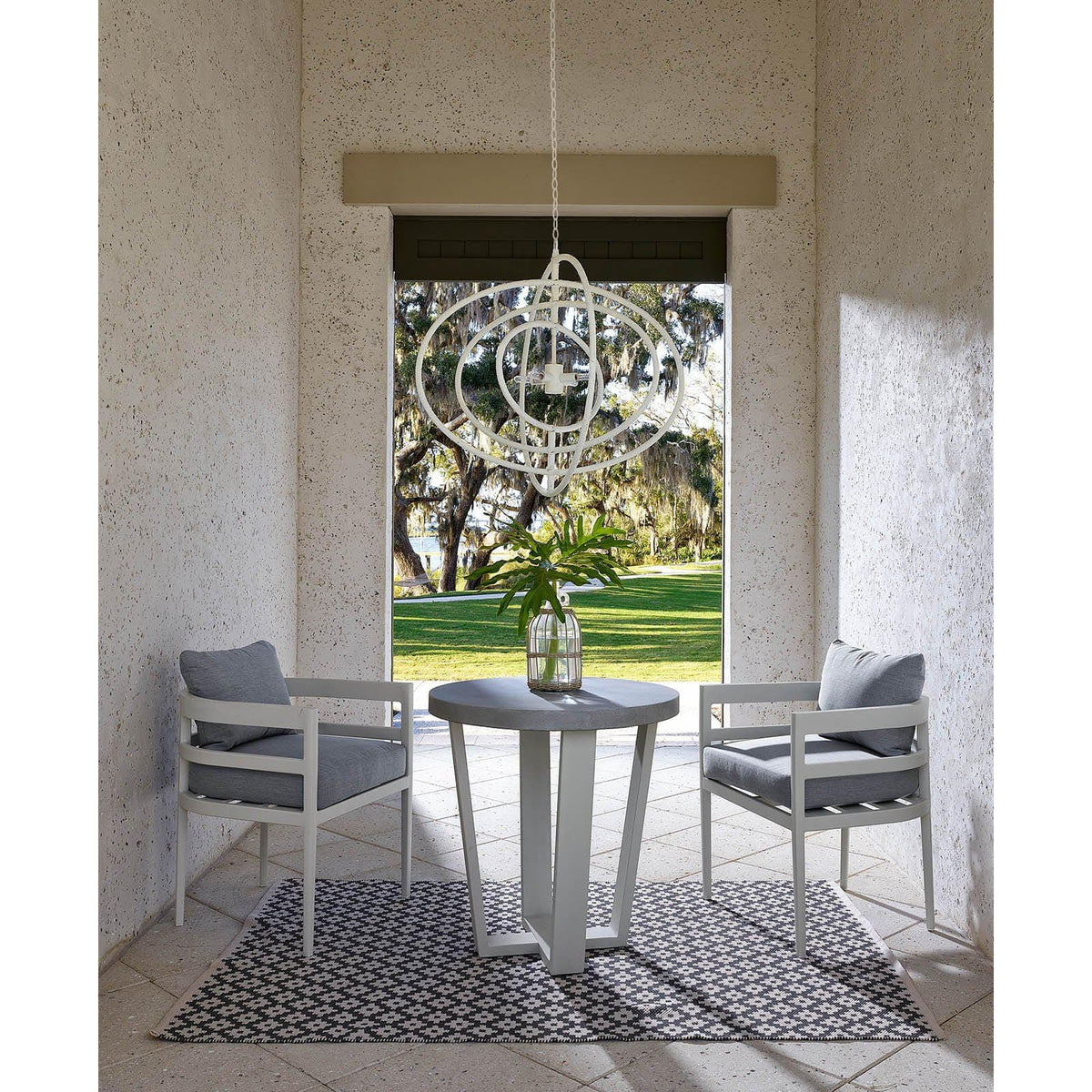 White Sail Chandelier with an airy, minimalist design, hanging above a patio table and chairs.