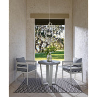 White Sail Chandelier with an airy, minimalist design, hanging above a patio table and chairs.
