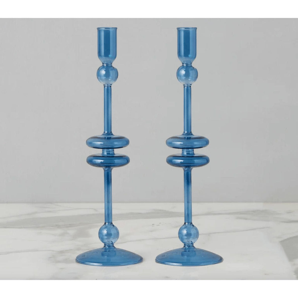 Pair of elegant 9"H sapphire blue glass candlesticks with a refined, modern design.