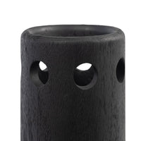Close-up of a black wooden vase with a sleek silhouette and three circular cutouts.