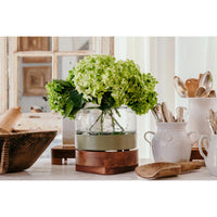 Decorative items including a vase with green flowers, wooden bowls, and kitchen utensils on a table.