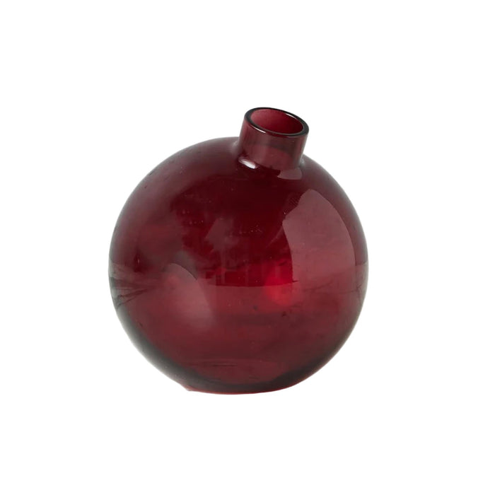 Red glass vase on a white surface with a white background
