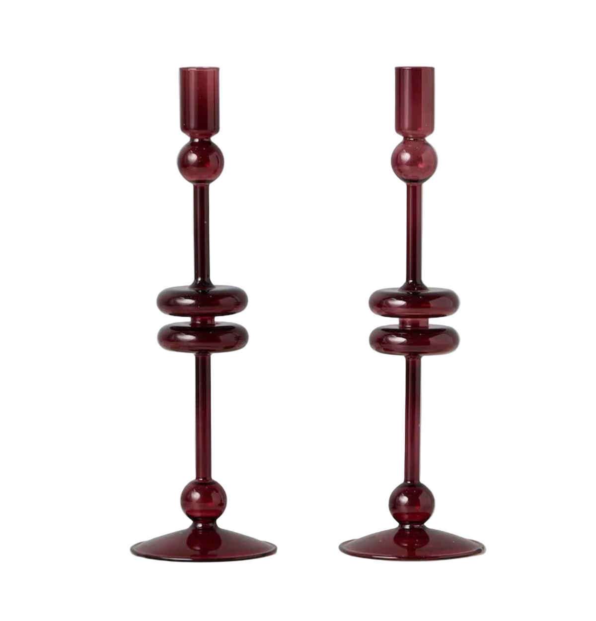 Two red glass candle holders on a white surface with a light gray background