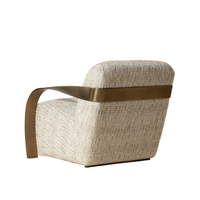 Modern armchair with textured fabric and bronze armrests on a beige background