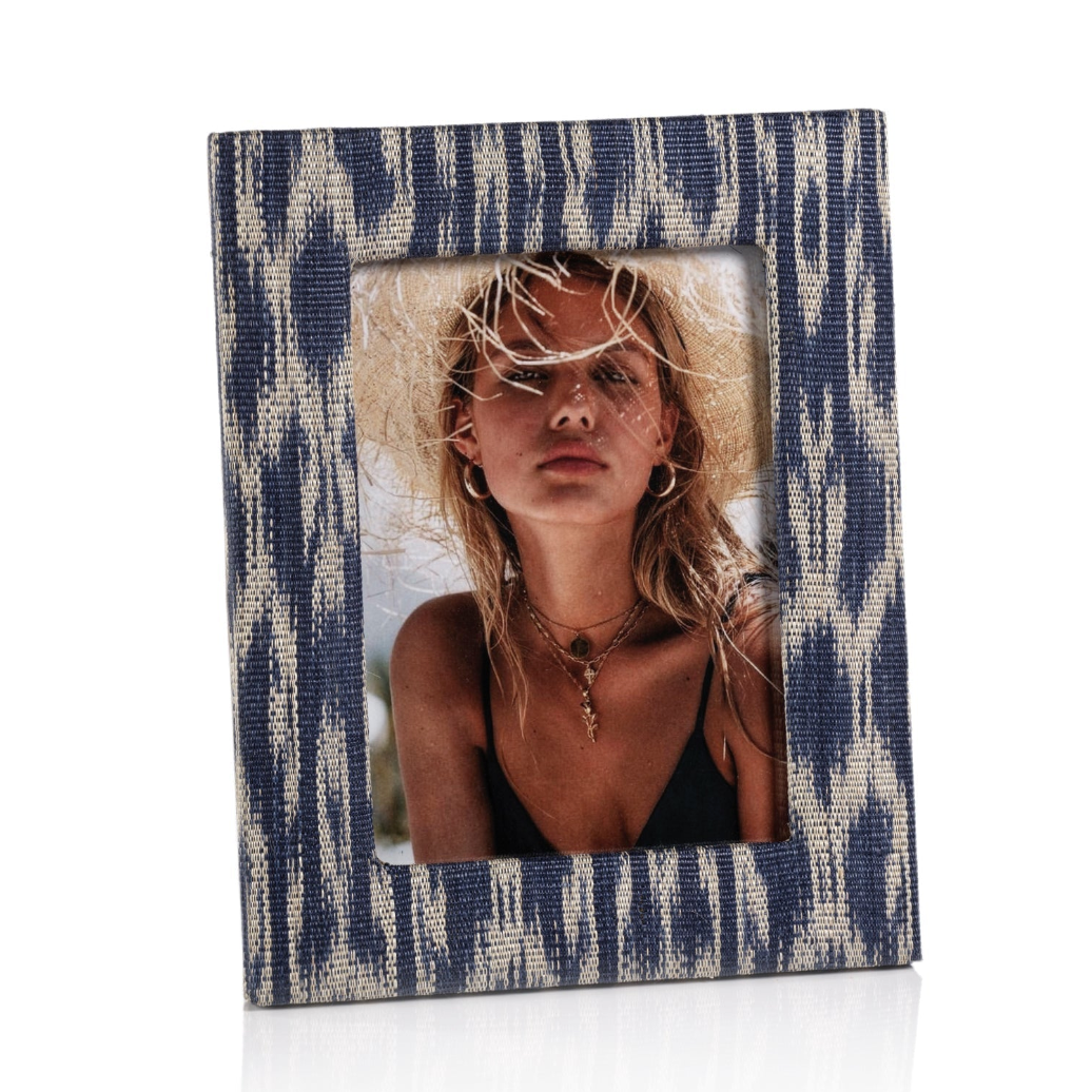 Blue and white patterned photo frame with a woman wearing a straw hat inside.