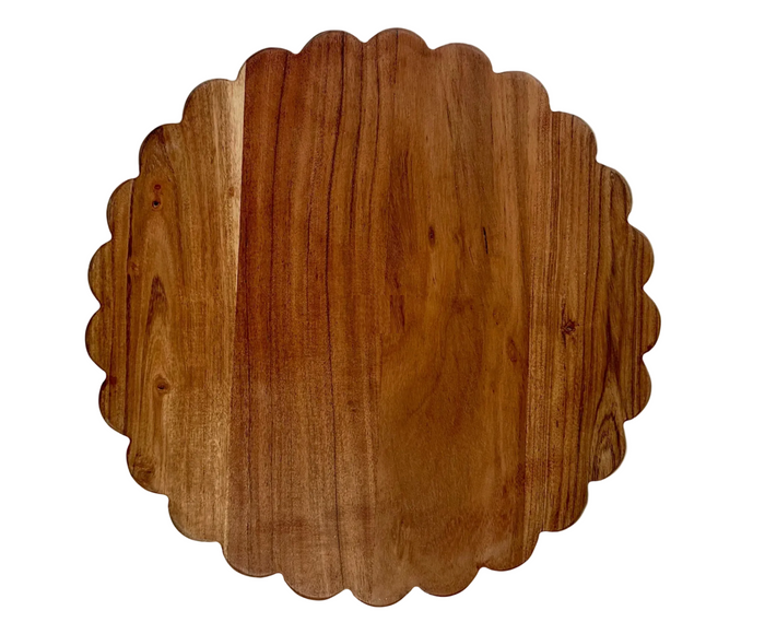 Wooden cutting board with scalloped edge on a white background
