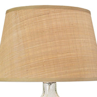 Seeded oval glass table lamp with a natural rattan tapered shade and polished nickel hardware.