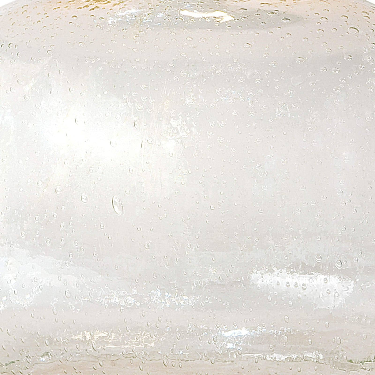 Close-up of a clear seeded glass table lamp base, showing its textured surface.