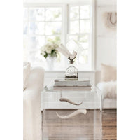 White selenite geode decorative glass bottle with crystal slabs and sticks on a clear acrylic table.