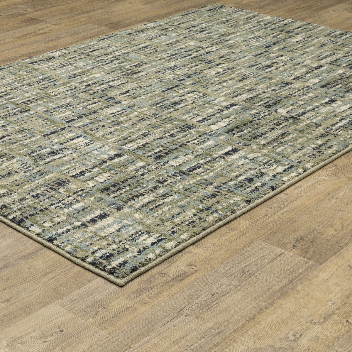 Seneca Beige & Green Casual Rug with modern abstract pattern on a wooden floor.