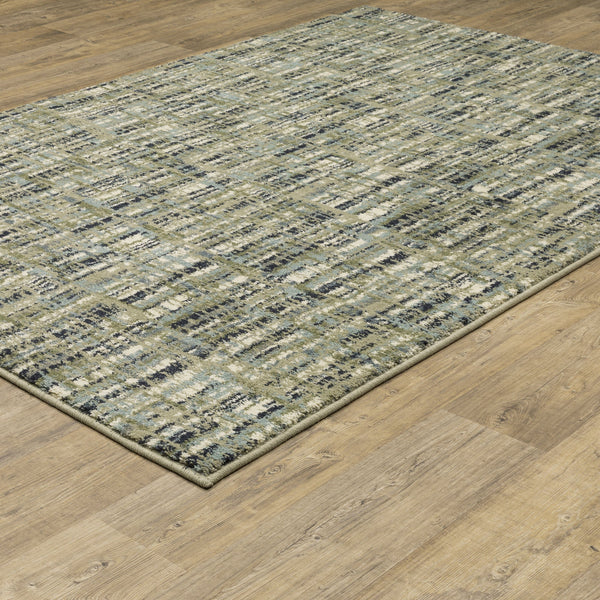 Seneca Beige & Green Casual Rug with modern abstract pattern on a wooden floor.