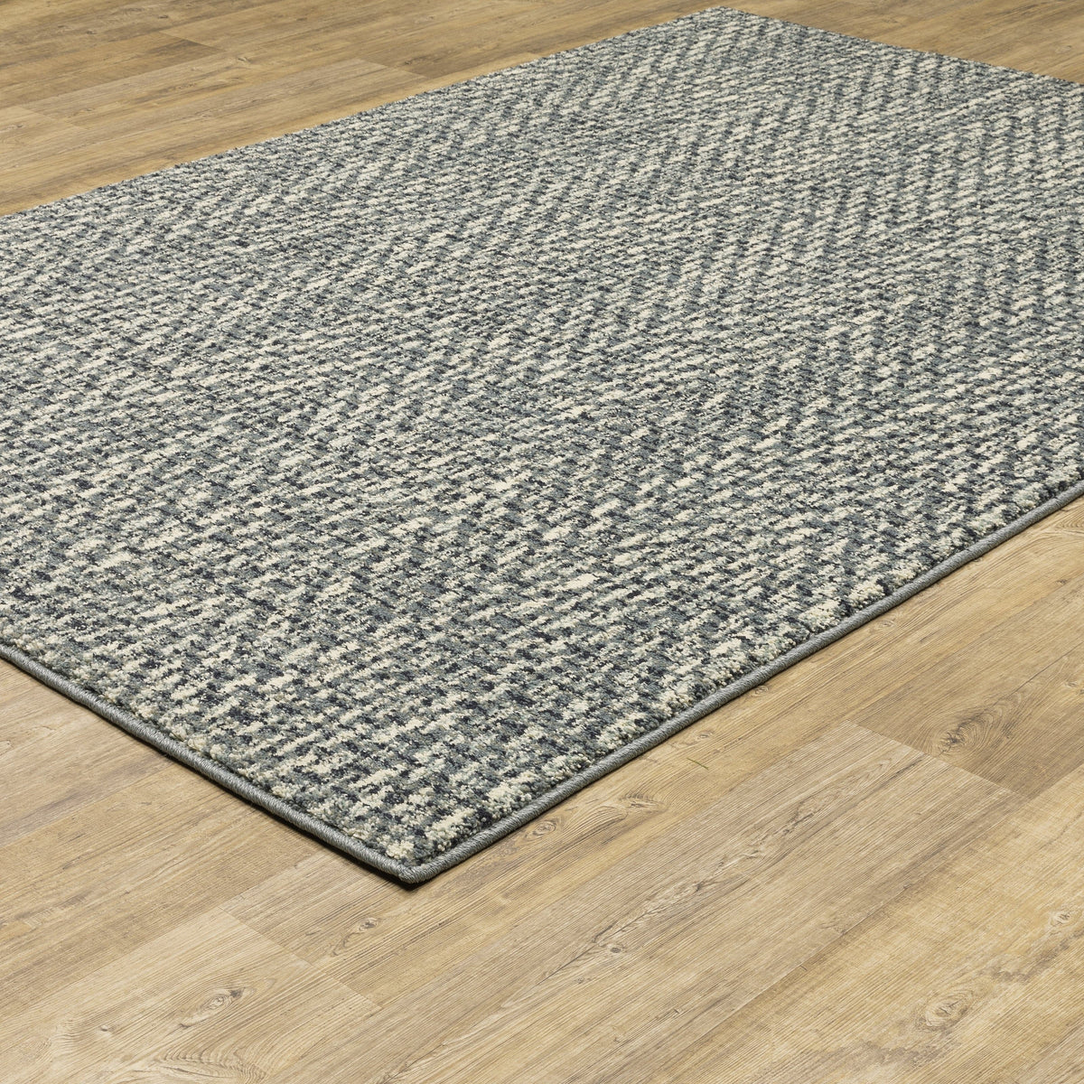 Seneca Blue & Ivory Casual Rug with modern organic geometric design on a wood floor.