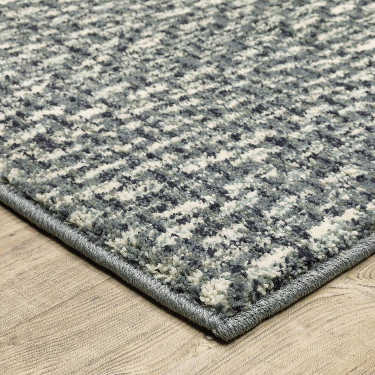 Seneca Blue & Ivory casual polypropylene rug with modern organic geometric design on wood floor.