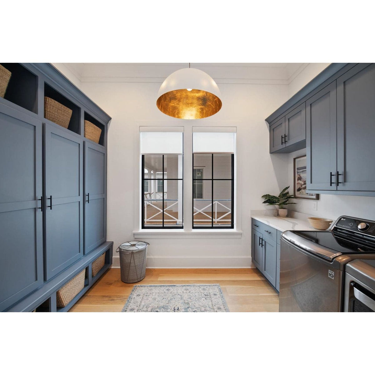 Large white dome pendant light with a gold-leafed interior hanging in a laundry room.