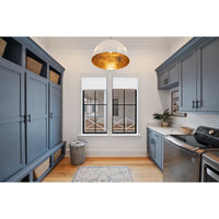 Large white dome pendant light with a gold-leafed interior hanging in a laundry room.