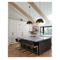 Two black and gold Sigmund pendant lights hang above a kitchen island with a marble top.