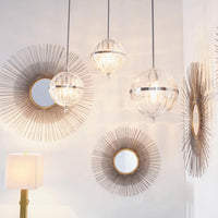 Antiqued silver leaf sunburst mirrors with radiating iron lines and clear glass pendant lights.