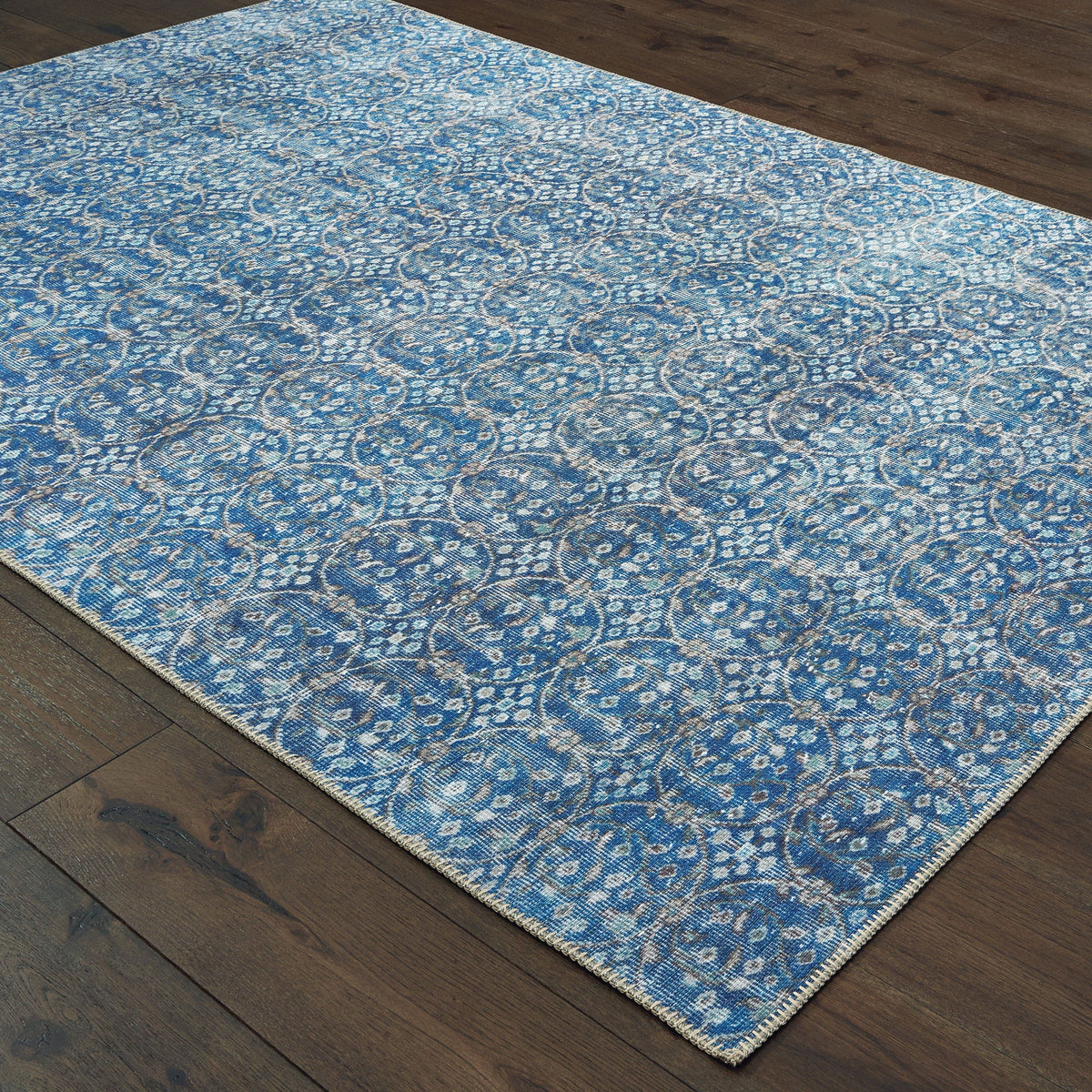 Sofia Blue & Brown Casual Rug with distressed traditional pattern on dark wood floor.