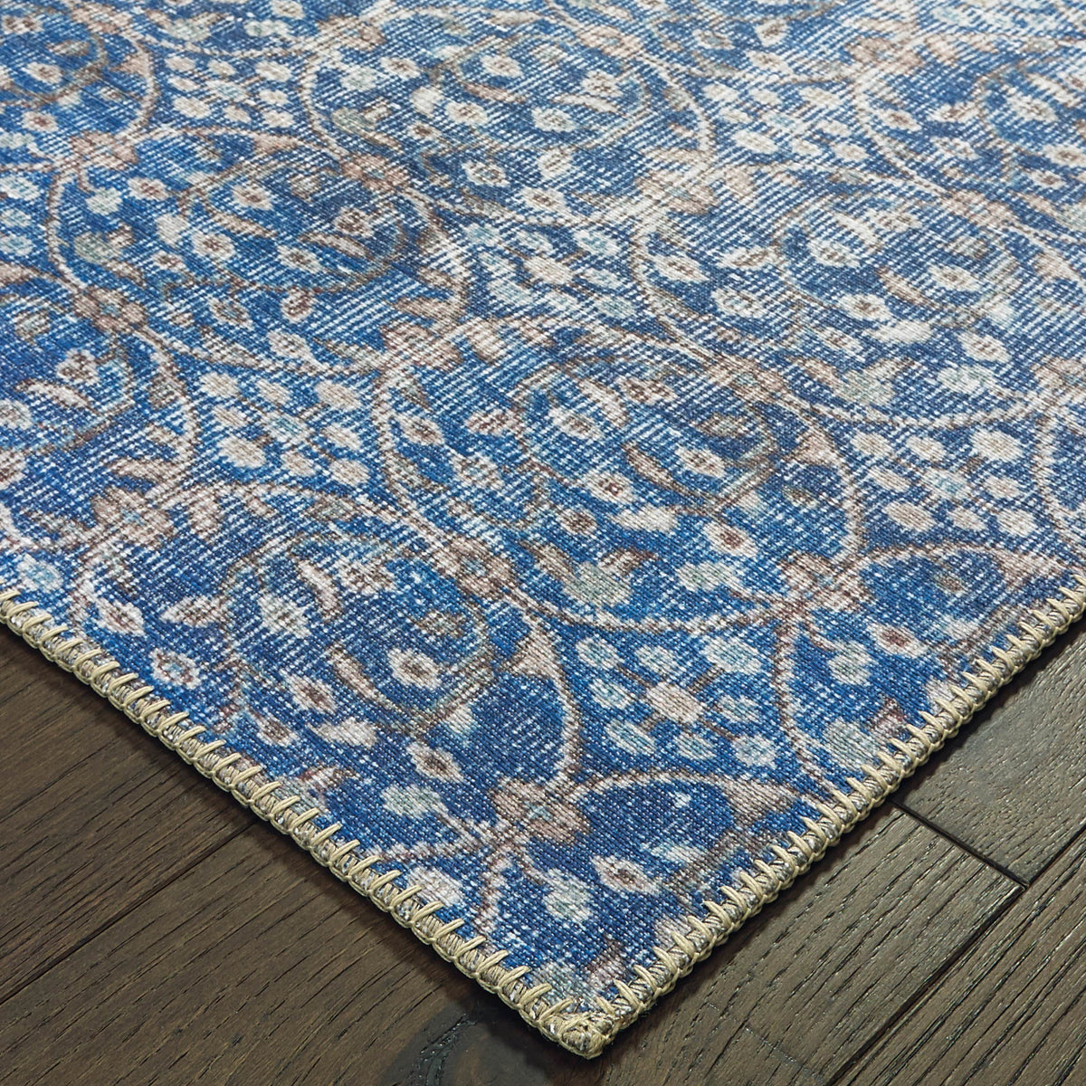 Sofia Blue & Brown Casual Rug with distressed traditional pattern, polyester chenille, and stitched edge on wood floor.