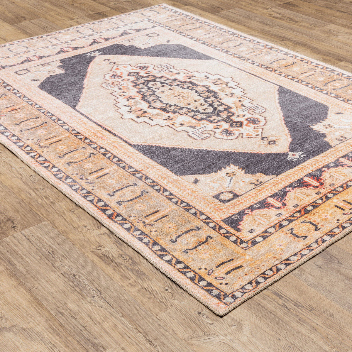 Sofia Gold & Charcoal Traditional Rug with distressed pattern on wood floor.