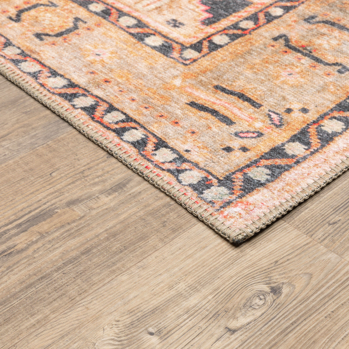 Sofia Gold & Charcoal traditional rug with distressed pattern on a wood floor.