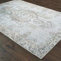 Sofia Grey & Gold Traditional Rug with distressed pattern on dark wood floor.
