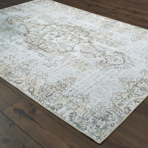 Sofia Grey & Gold Traditional Rug with distressed pattern on dark wood floor.
