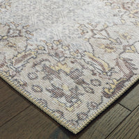 Sofia Grey & Gold Traditional Rug with distressed pattern, polyester chenille, on a dark wood floor.