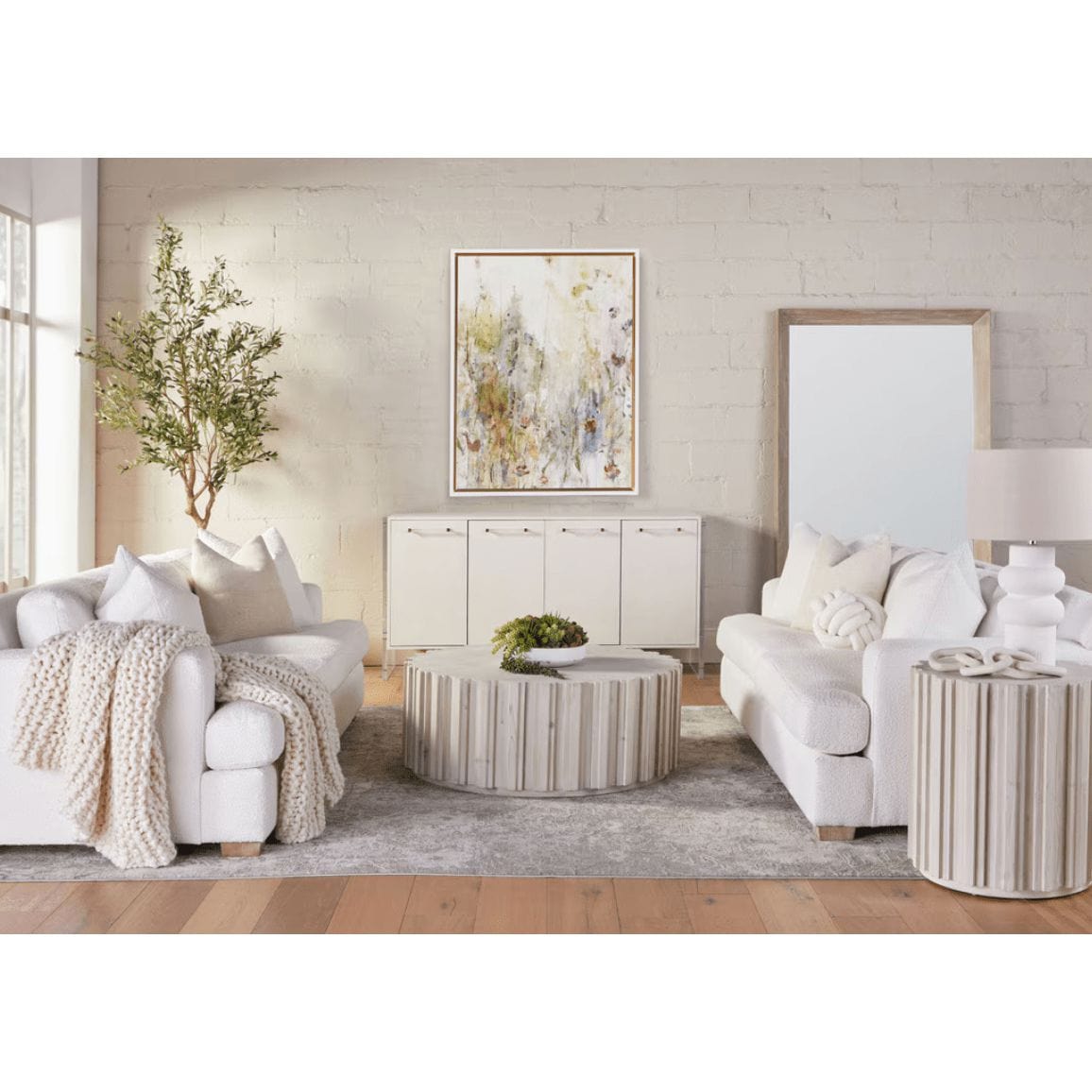 Pearl white faux shagreen media sideboard with clear acrylic and brushed brass accents in a living room.
