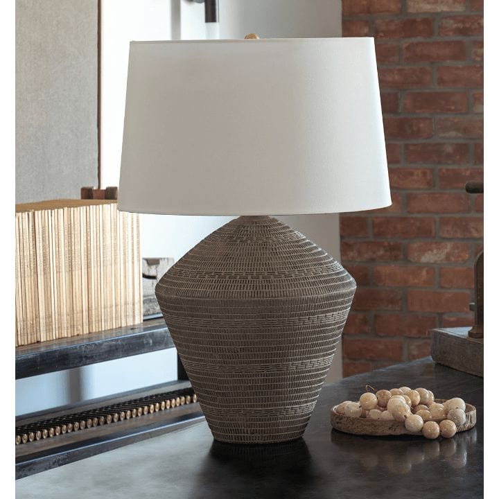 Soren ceramic table lamp with an etched earthenware base and a white linen shade on a dark surface.