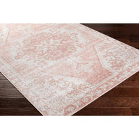 St Tropez pale pink and beige polypropylene rug with a traditional design on dark wood flooring.