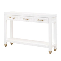 Stella matte white narrow console table with three drawers, gold pulls, a bottom shelf, and gold-capped feet.
