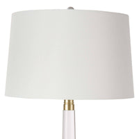 Stowe crystal table lamp with a clear sculptural base, polished brass accents, and a white linen shade.