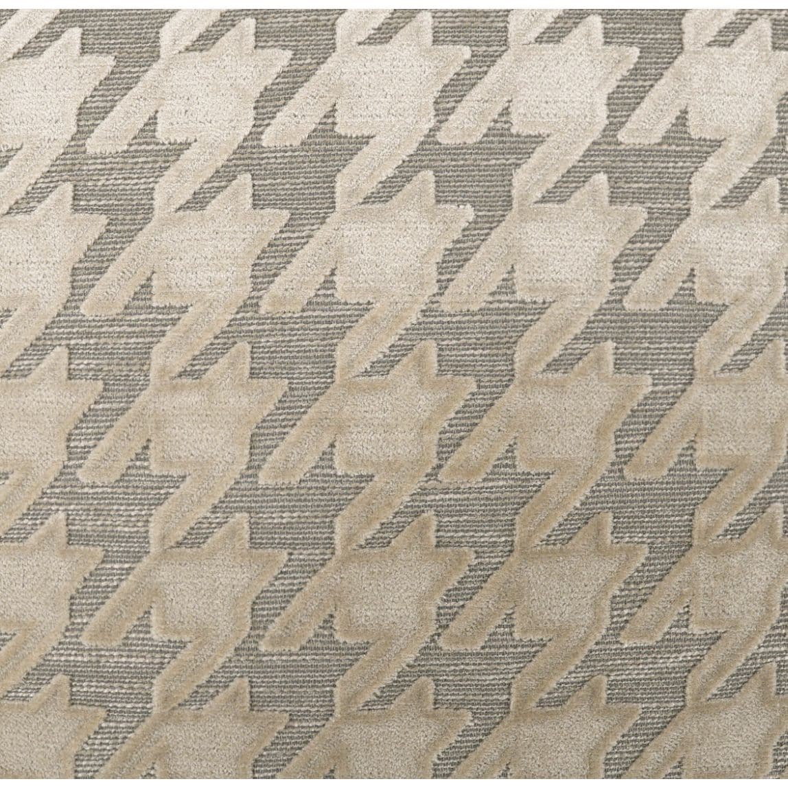 Beige mist throw pillow with a raised houndstooth pattern on a textured gray background.