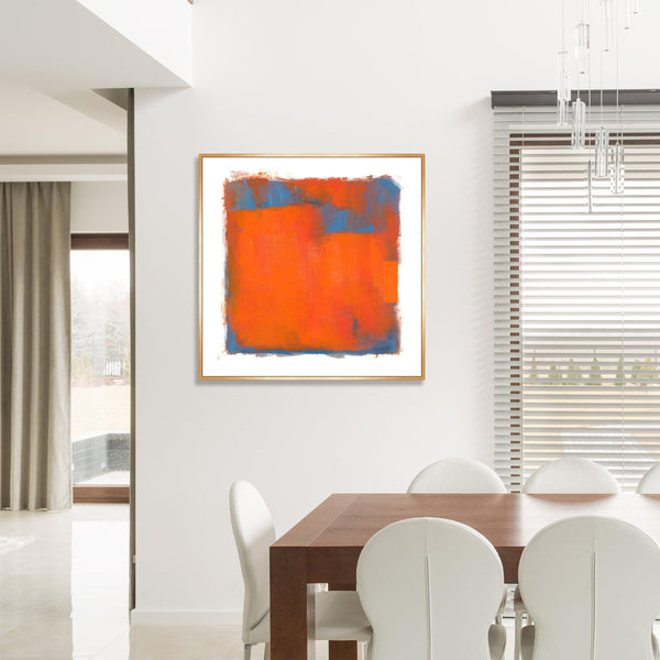 Abstract giclee canvas painting with orange and blue color blocks in a gold frame, displayed in a modern dining room.