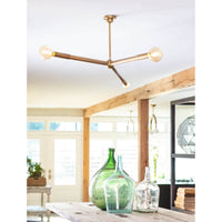 Talon Chandelier in natural brass with three exposed bulbs, featuring adjustable arms in a modern, minimalist design.