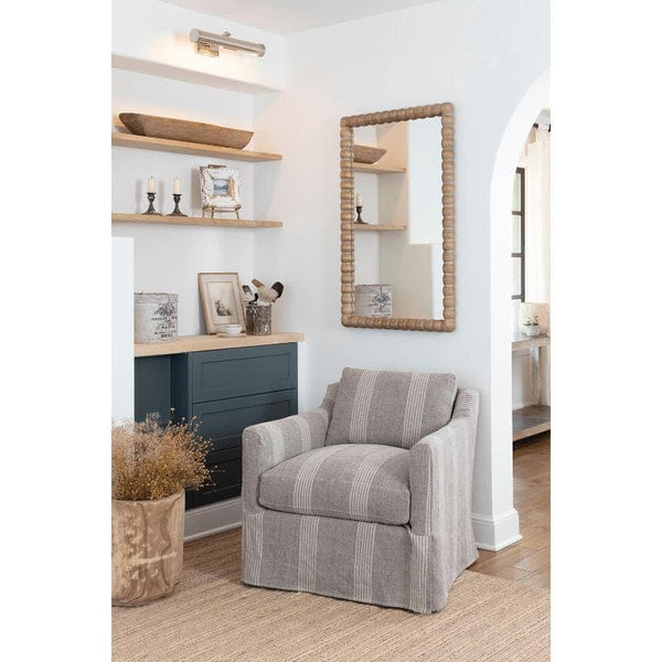 Polished nickel Tate Picture Light illuminates a wall niche with wooden shelves and decor.