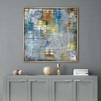 Abstract giclee canvas painting with blue, yellow, and orange tones in a gold frame over a gray cabinet.