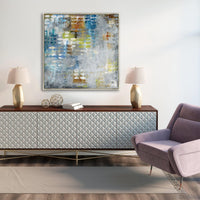 Abstract giclee canvas painting with blue, yellow, and white tones above a textured white console and purple chair.