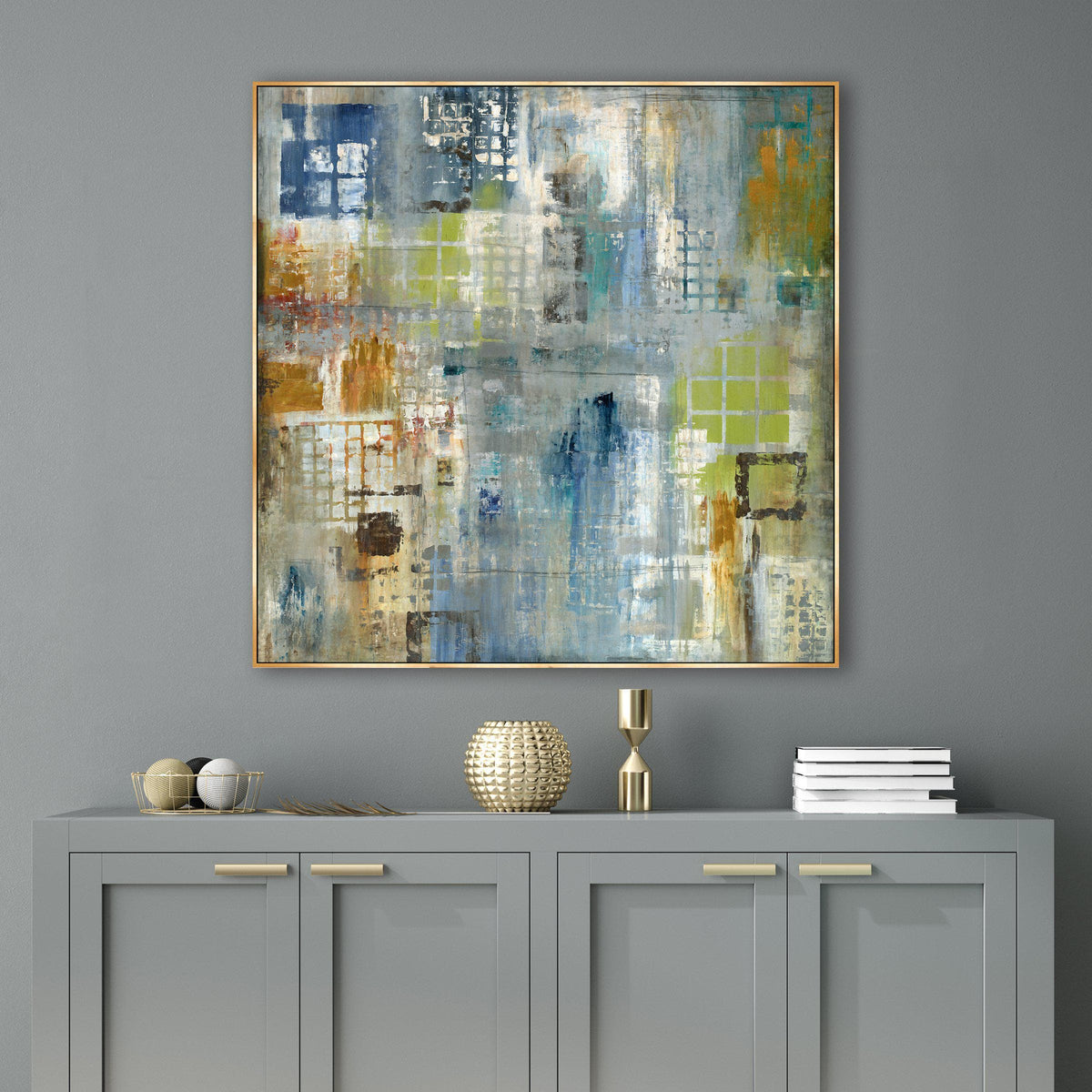 Abstract giclee canvas painting with blue, green, and orange tones in a gold frame over a gray cabinet.