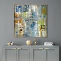 Abstract giclee canvas painting with blue, green, and orange tones in a gold frame over a gray cabinet.