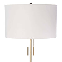 Theo Floor Lamp with a white linen shade, ebony birch wood, and brass accents.