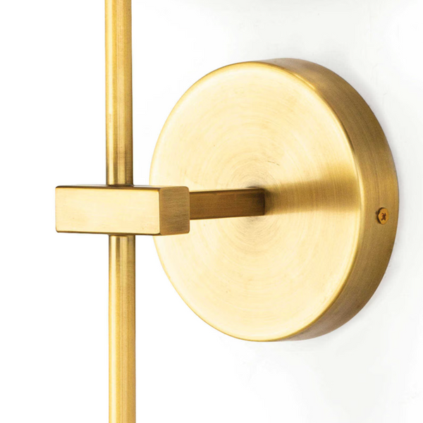 Toni Brass Sconce with a circular backplate, sleek pipe, and natural linen shade.