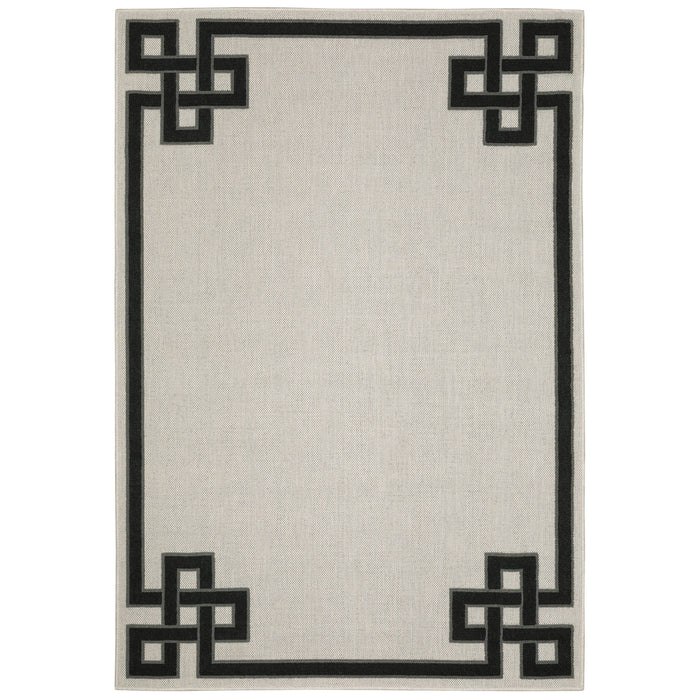 Torrey Beige & Black Outdoor Rug with a flatwoven base and black geometric loop pile border.