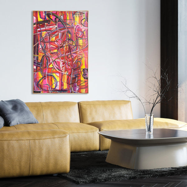 Abstract giclee canvas painting, "Traveling Through Eden," with vibrant red, pink, and yellow brushstrokes, hanging above a yellow leather sofa.