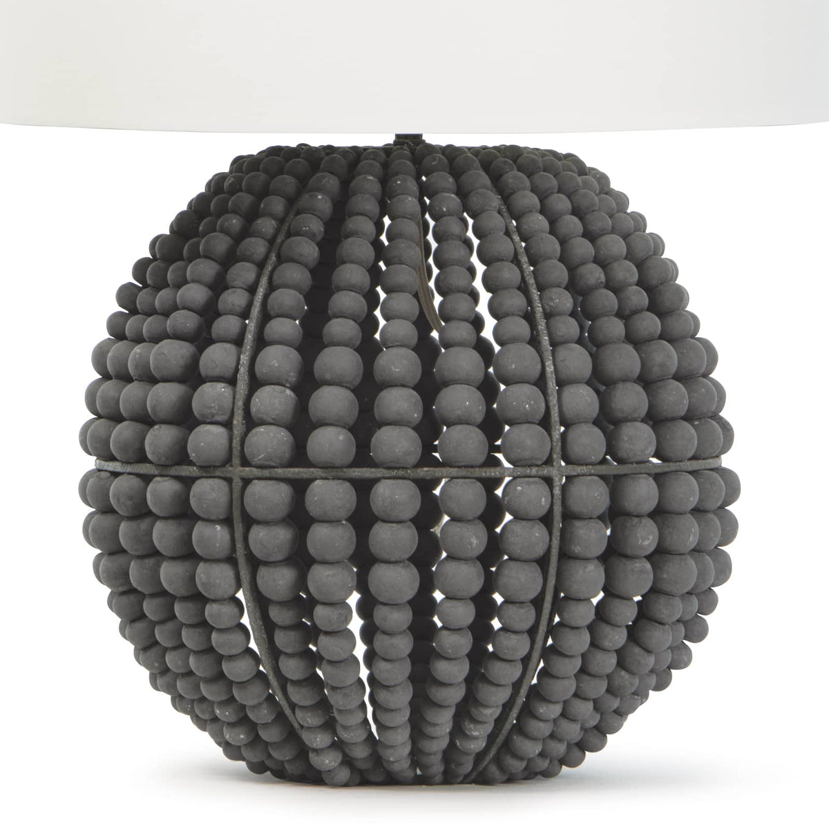 Tropez table lamp with a spherical base of distressed charcoal grey wooden beads and a white linen shade.