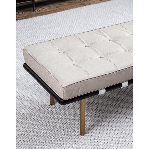 Tufted cappuccino leather gallery bench with black frame and gold legs on a white textured rug.