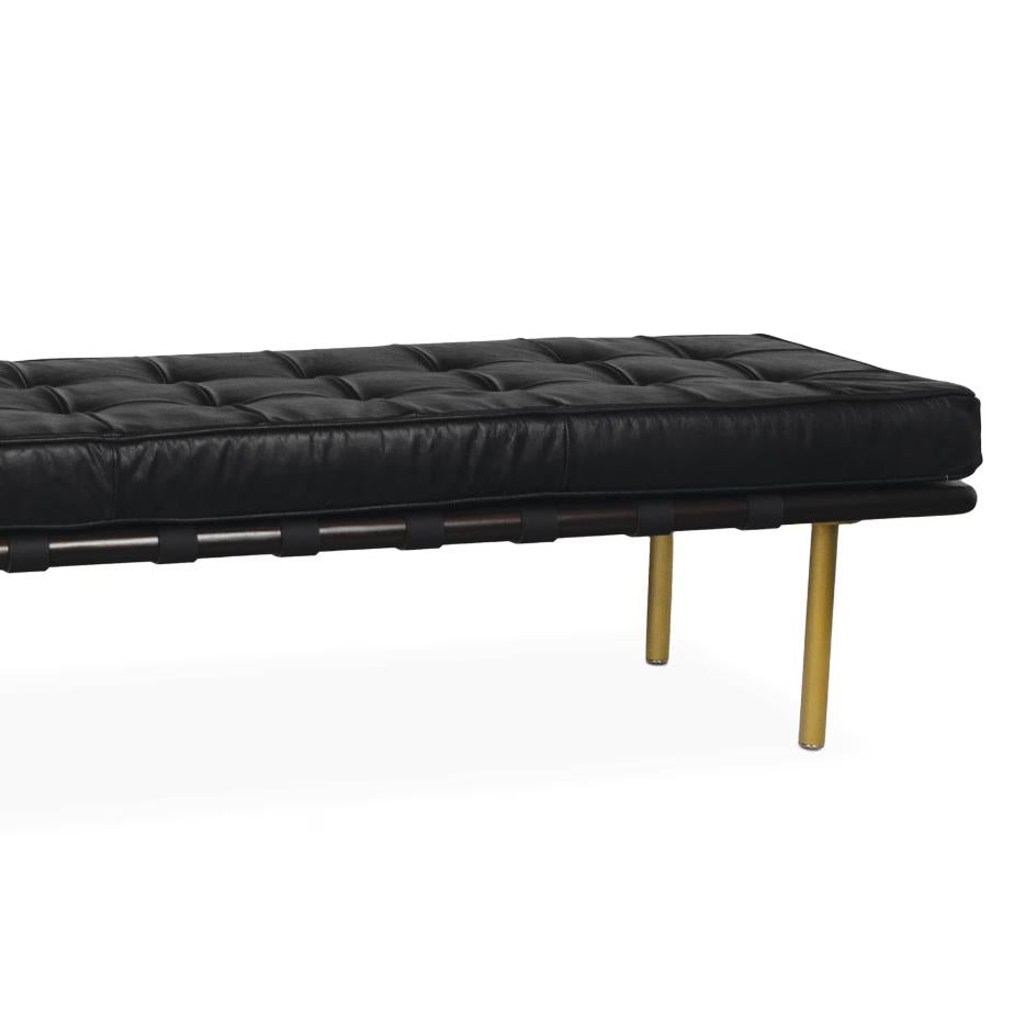 Modern black tufted leather gallery bench with dark wood frame and gold legs.