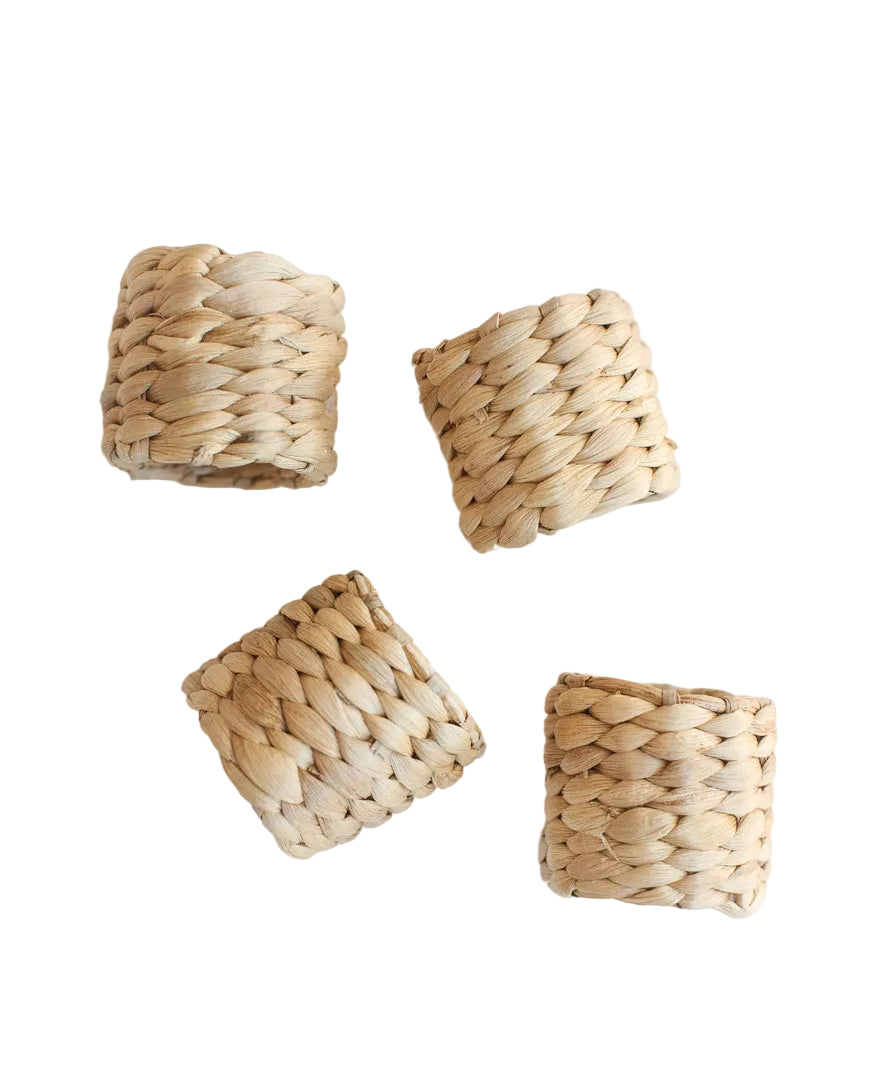 Four woven napkin rings on a white background