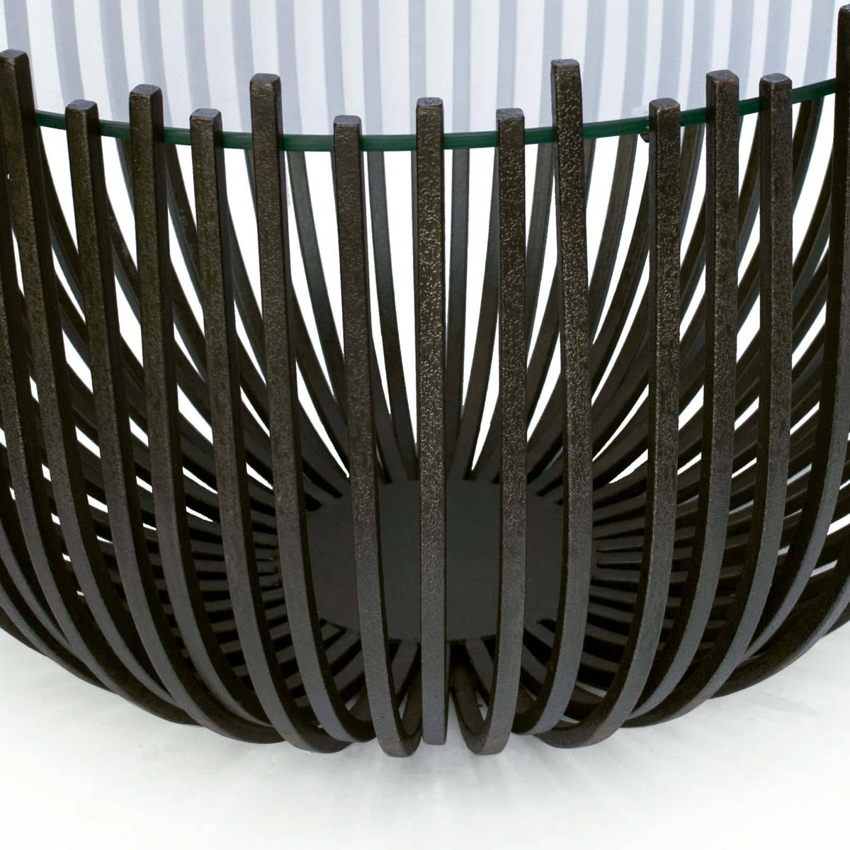 Sculpted webbed blackened iron coffee table with a glass top, 30" wide.